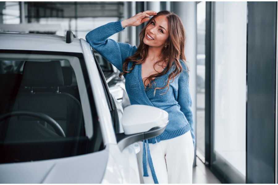 woman leaning on new car