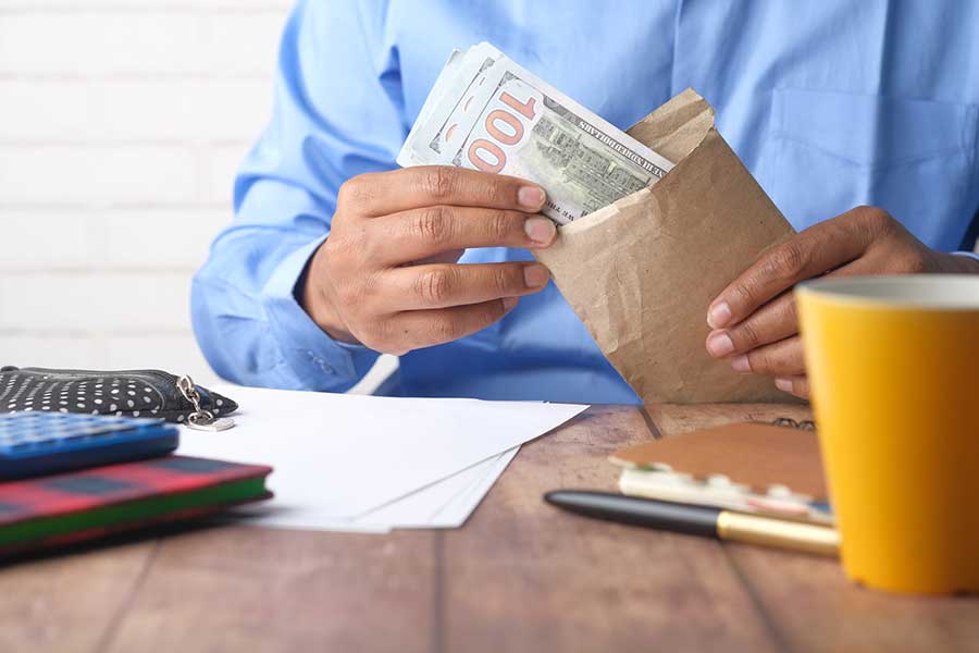 man putting cash in envelope