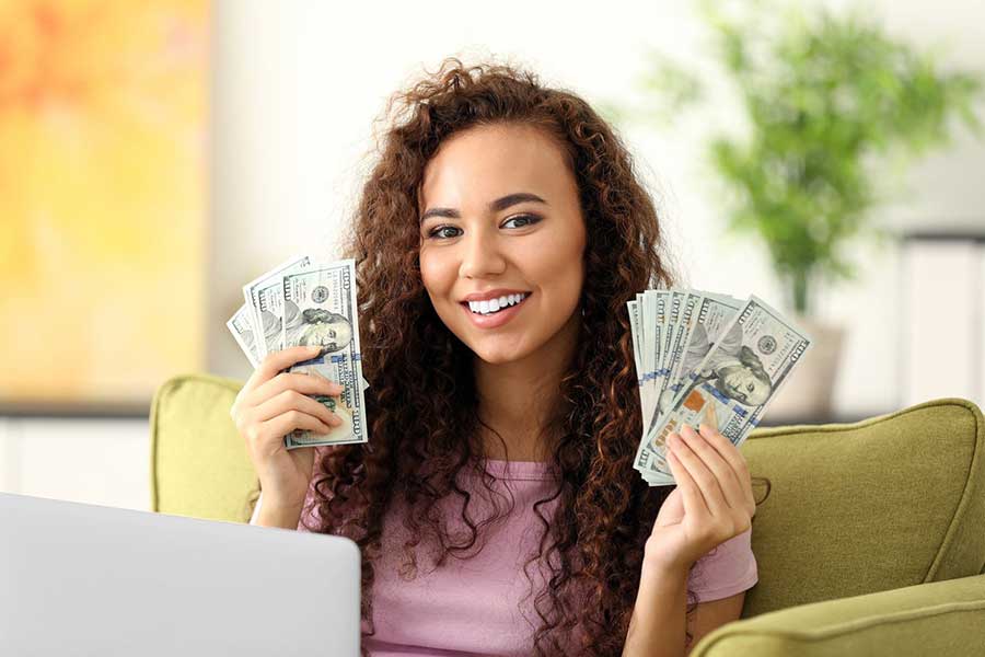 woman holding hundred dollar bills