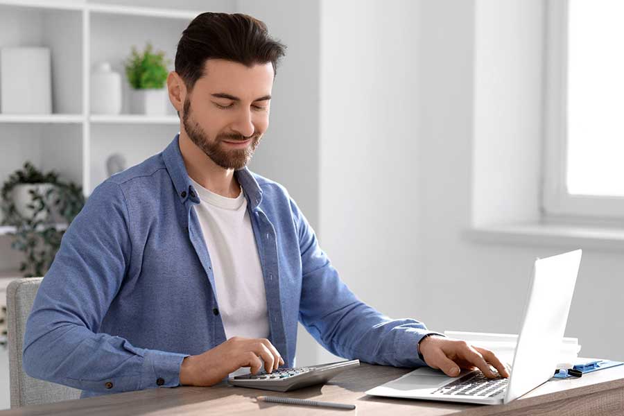 man calculating yield on laptop