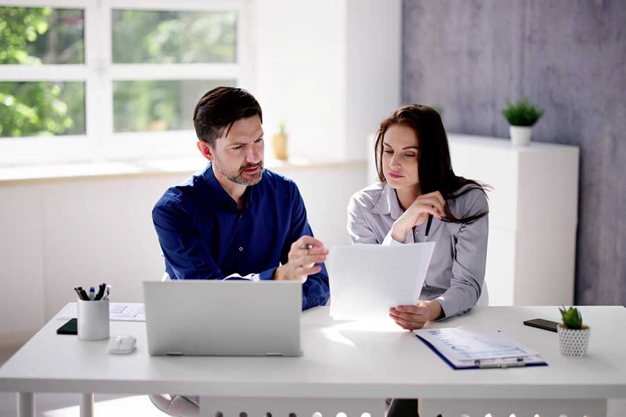 couple reviewing investments on laptop