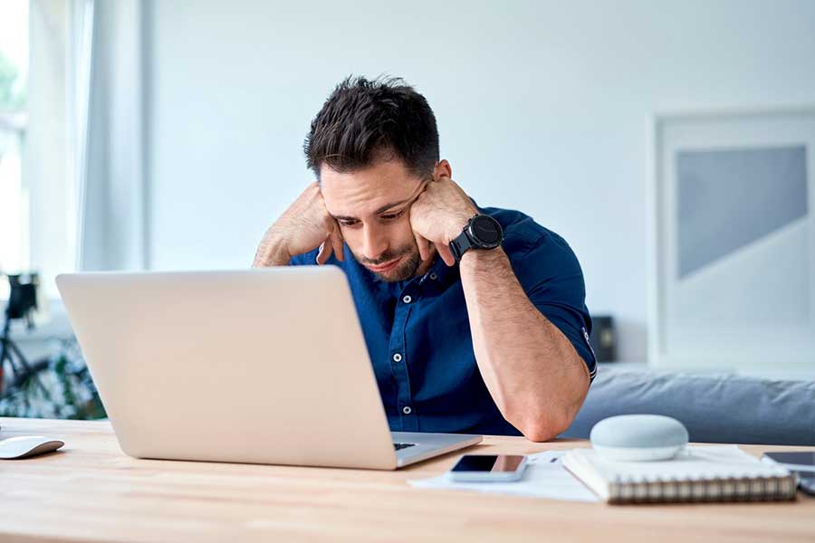 man looking at credit report on laptop