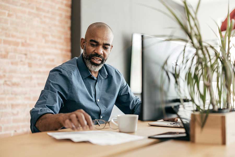 man managing money on laptop
