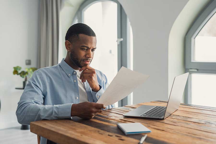 man reading letter at desk