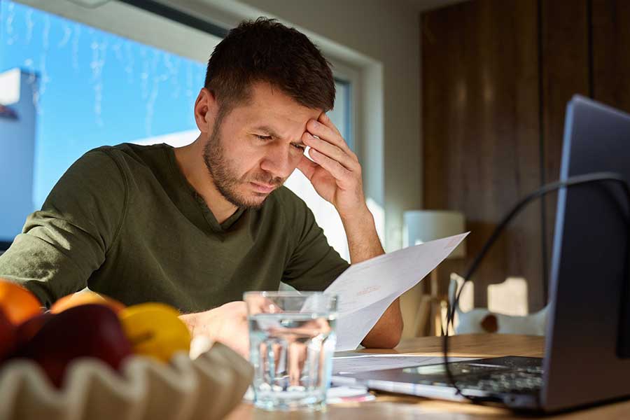 stressed man looking at credit card bill