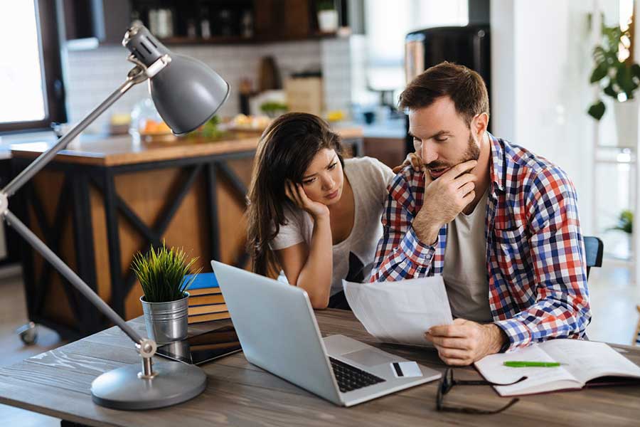 stressed couple looking at bills